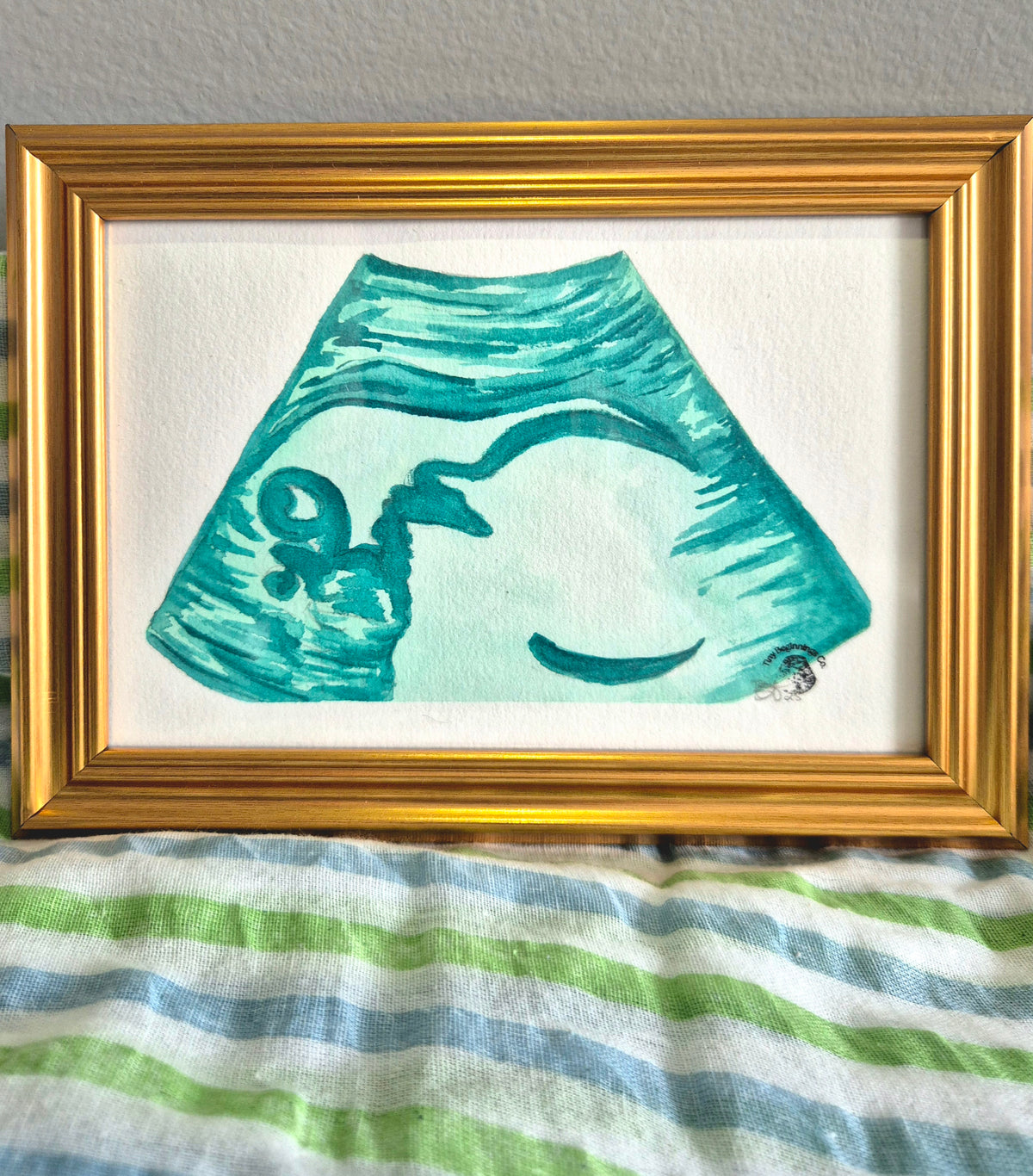 blue green watercolour ultrasound painting in gold frame