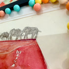 trail of elephants on top of ultrasound artwork, surrounded by colourful beads